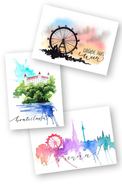 Drei Aquarell-Postkarten von Tanja Mayer mit Stadtmotiven: Riesenrad bei Sonnenuntergang mit Schrift "Grüße aus Wien", Burg von Bratislava mit Schriftzug "Bratislava" und die Skyline von Wien mit Schrift "Vienna".