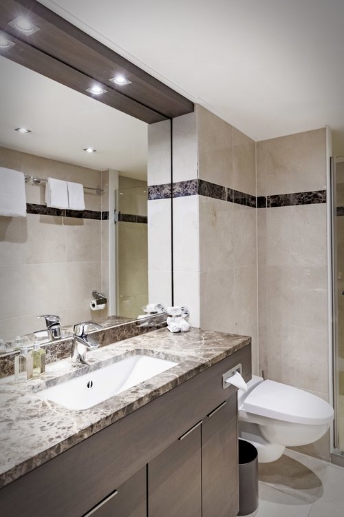 Ein helle eingerichtetes Bad an Bord der A-ROSA CLEA mit WC, Dusche und großzügigem Waschbereich.