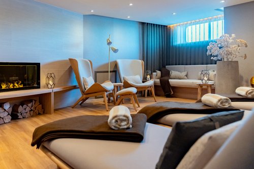 Stilvoller Ruheraum an Bord der A-ROSA SENA mit Kamin, Liegestühlen und gemütlicher Einrichtung im skandinavischen Stil.