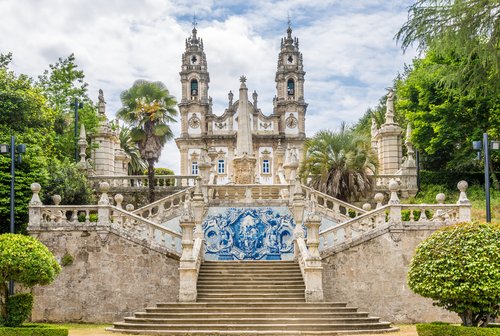 Barocke Kirche mit zwei Türmen und Uhr in Lamego, davor breite Steintreppe mit blau-weißem Azulejo-Fliesenbild und symmetrischen Balustraden